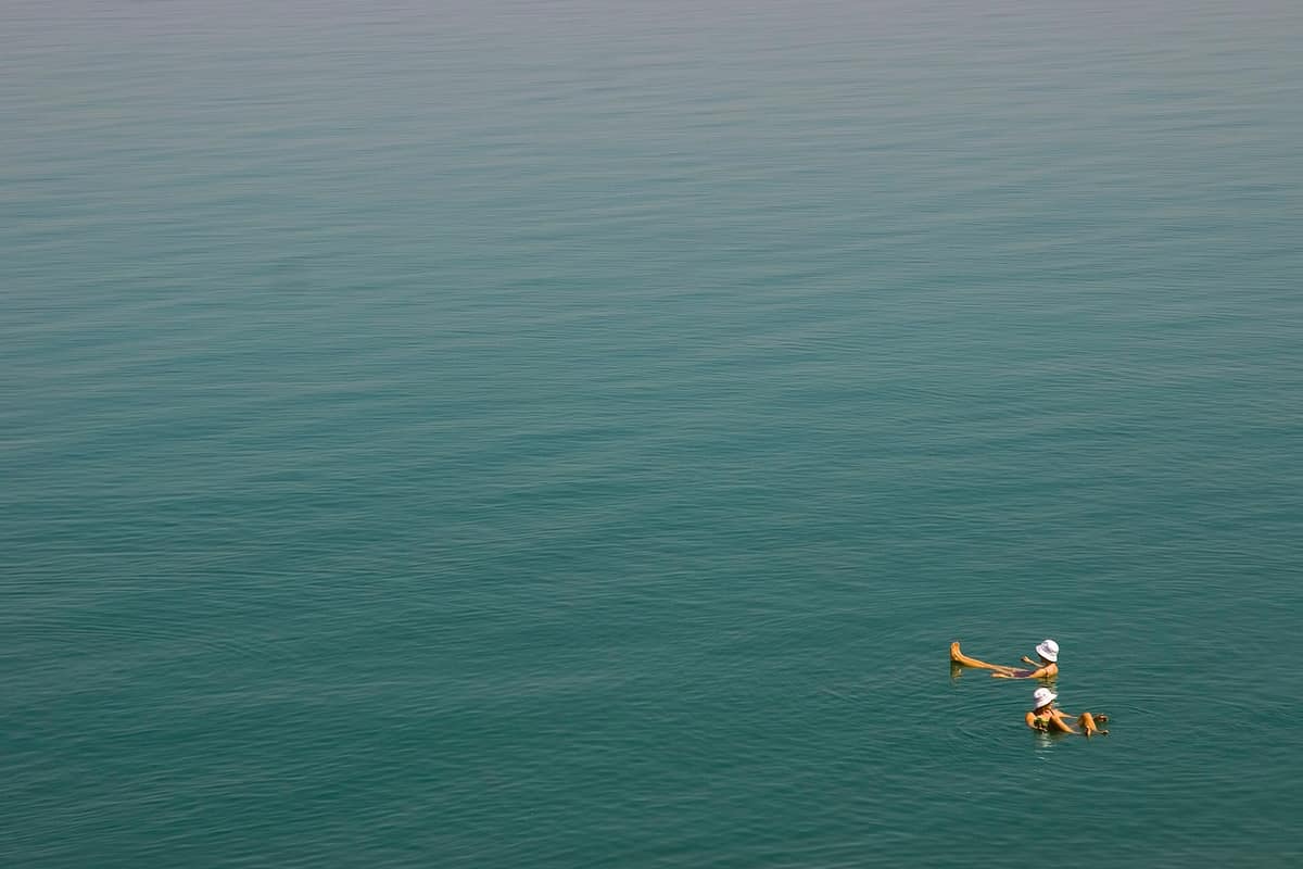 Bathers floating upright on the surface of the Dead Sea