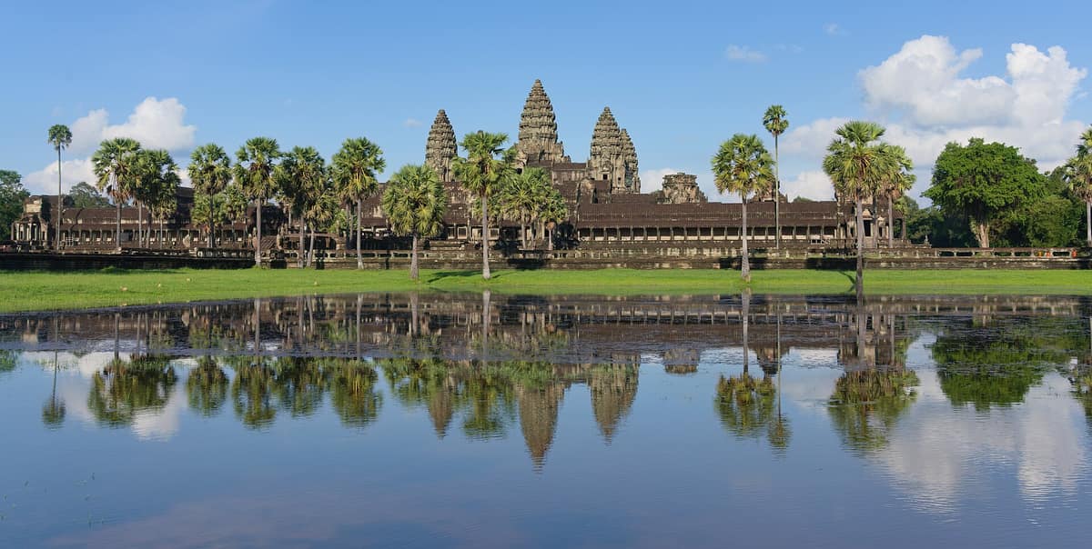 The towers of Angkor Wat reflected in the water of its moat