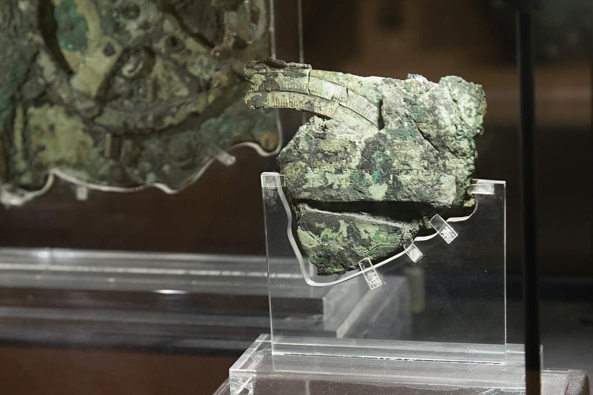 The corroded bronze fragment of the Antikythera mechanism in a museum case